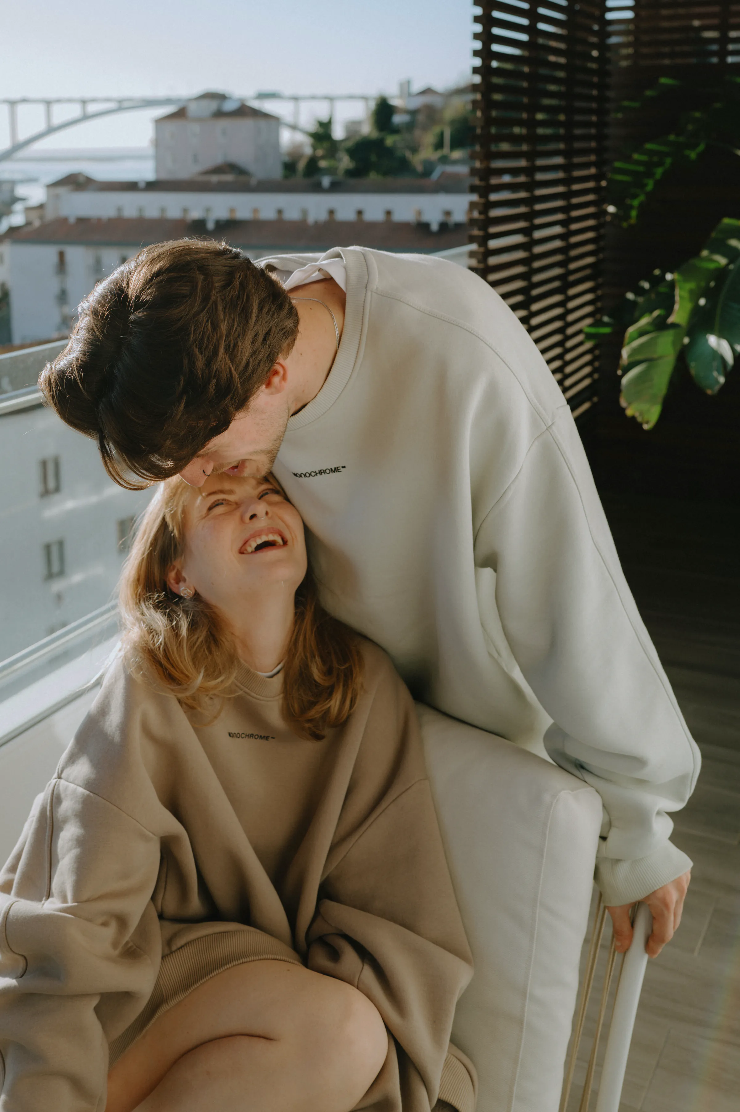 Close portrait of a couple on a balcony during a softly lit city session.