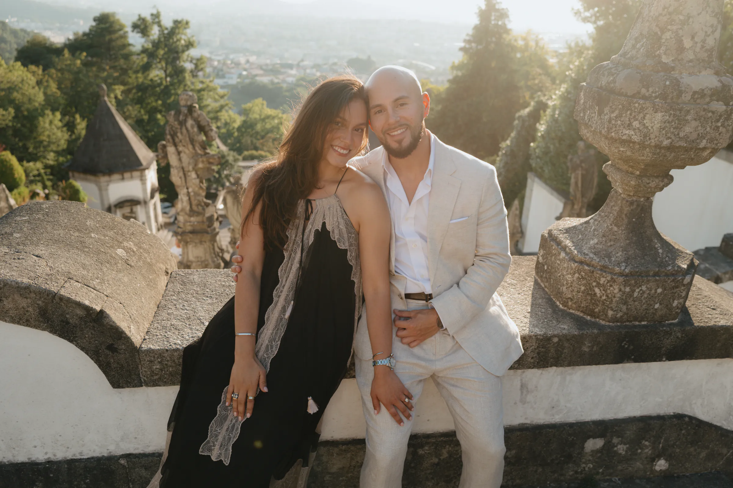 Couple portrait on a stone terrace during an outdoor session with soft light and hillside views.