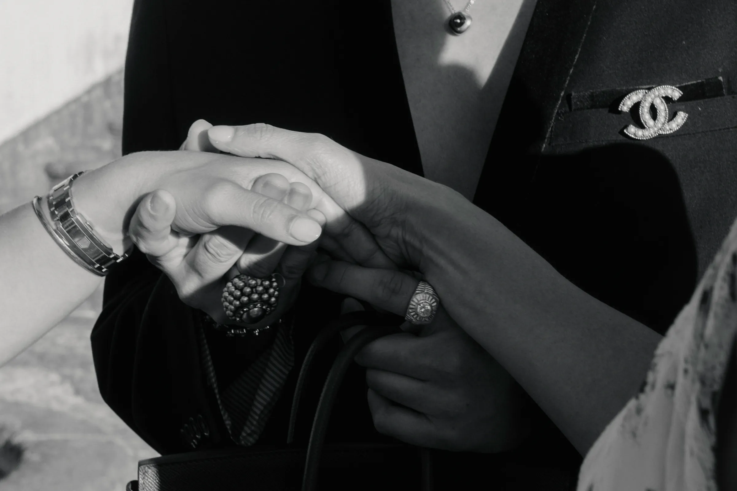 Close portrait of a couple’s hands during a formal ring exchange in black and white.