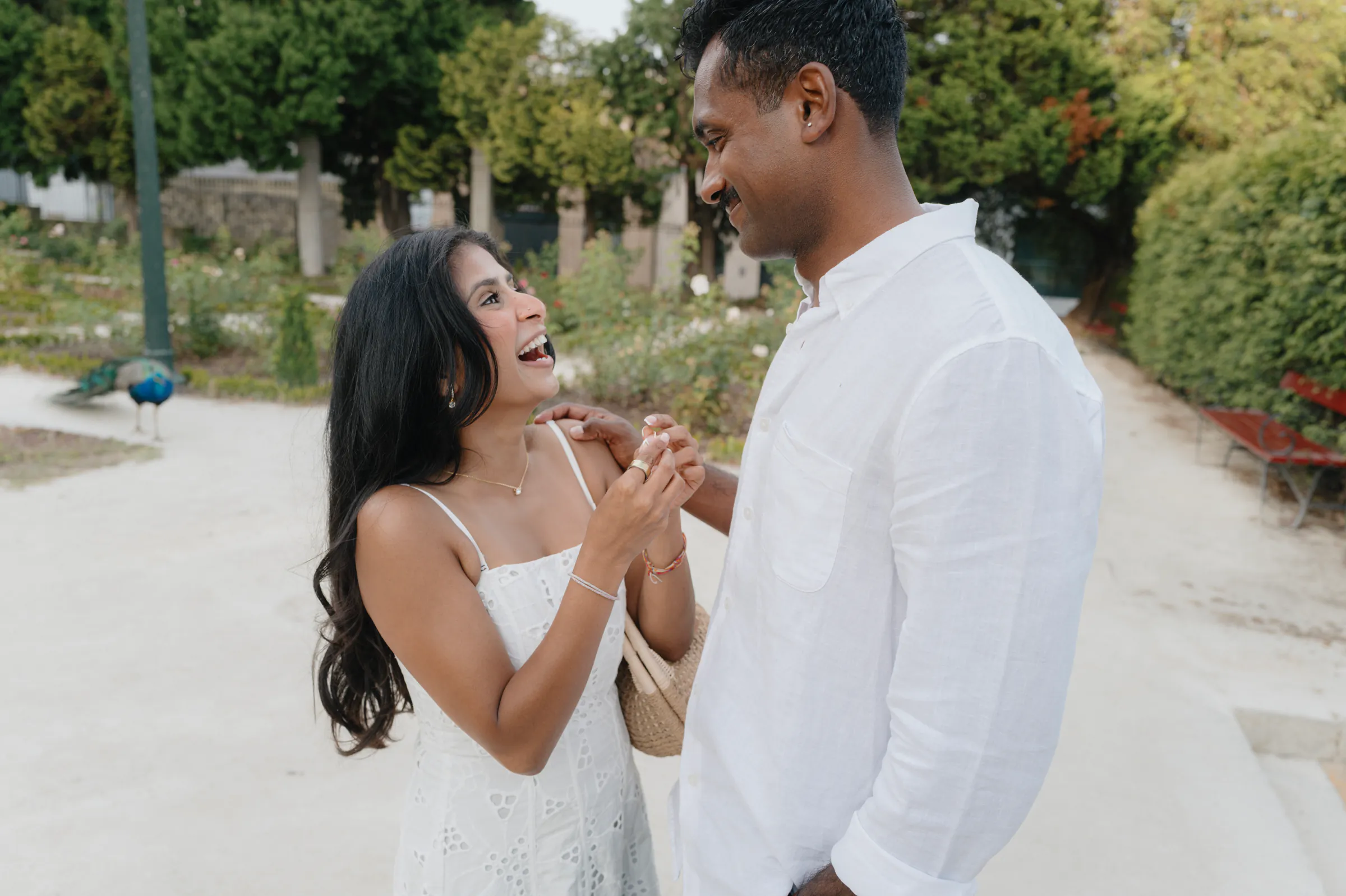 Couple during an outdoor session on a garden path, holding hands in soft light.